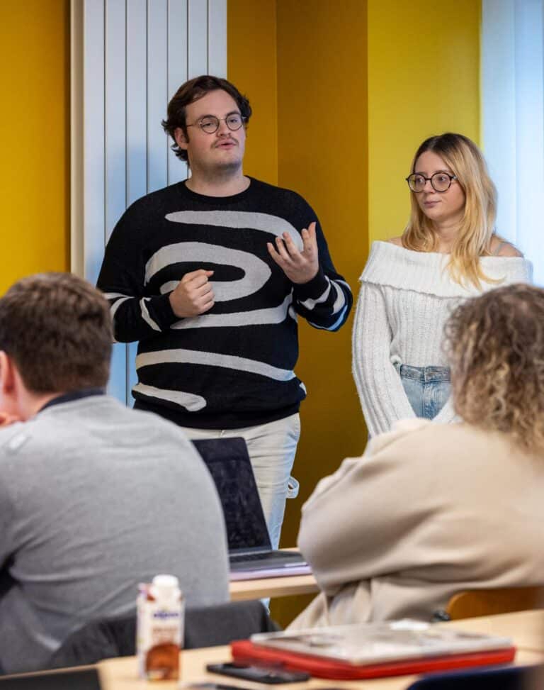 Photo d'un projet d'éloquence au CESACOM, mettant en scène des étudiants s'exprimant avec assurance devant un public.